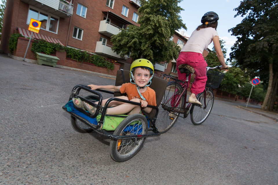 Barn bakpå en cykelkärra.