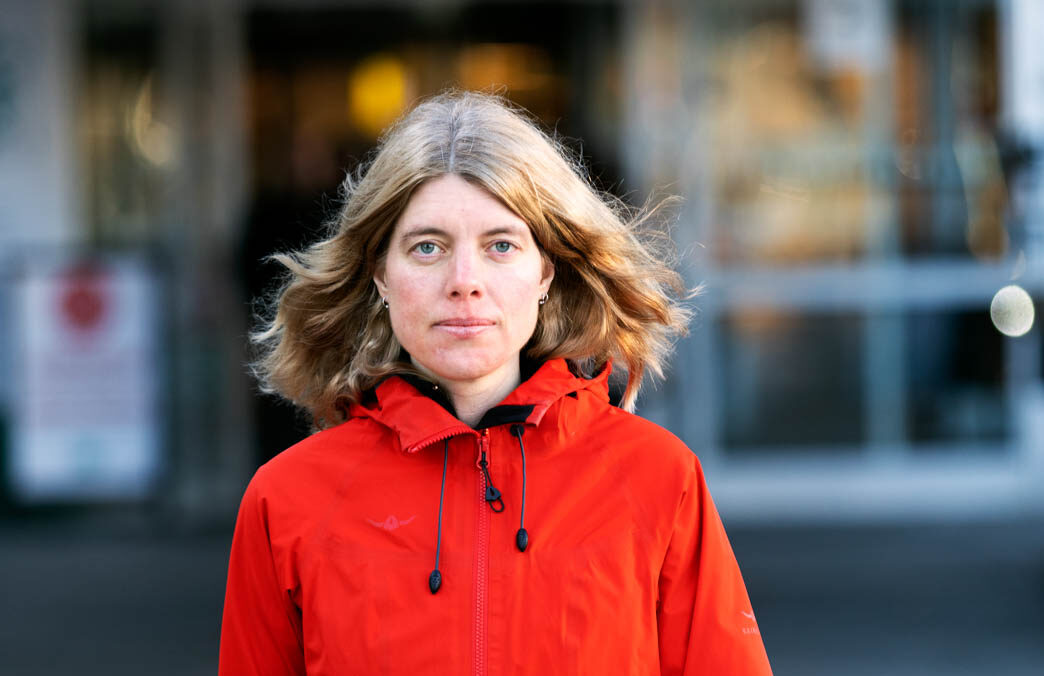 Anna Sehlin går framför ett sjukhus. Hon har röd jacka på sig.
