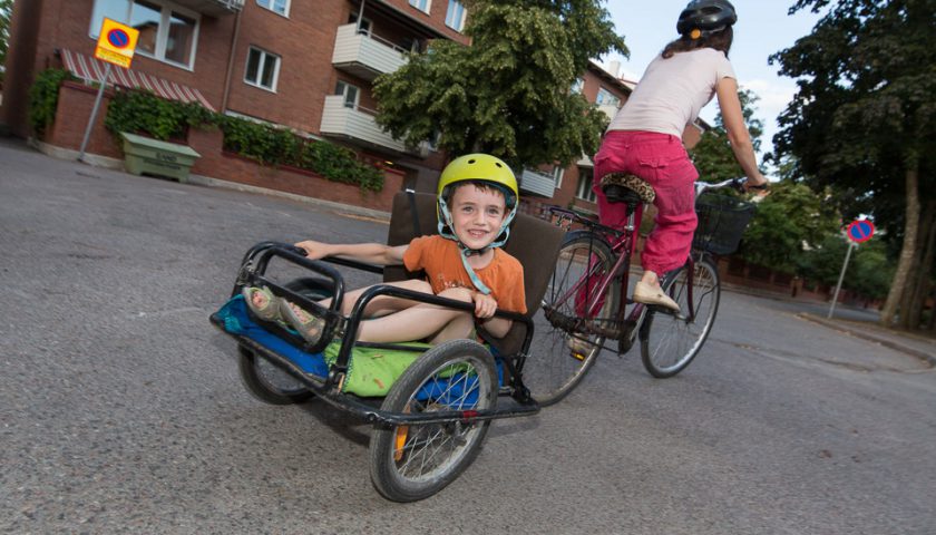 Barn bakpå en cykelkärra.