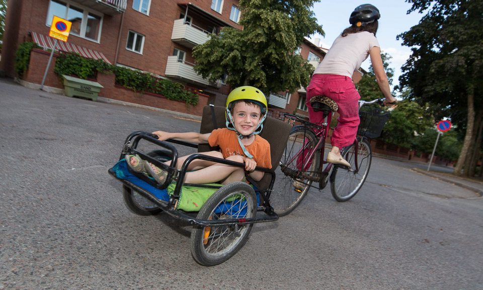Barn bakpå en cykelkärra.