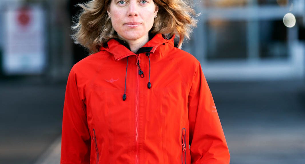 Anna Sehlin går mot kameran klädd i en röd jacka.