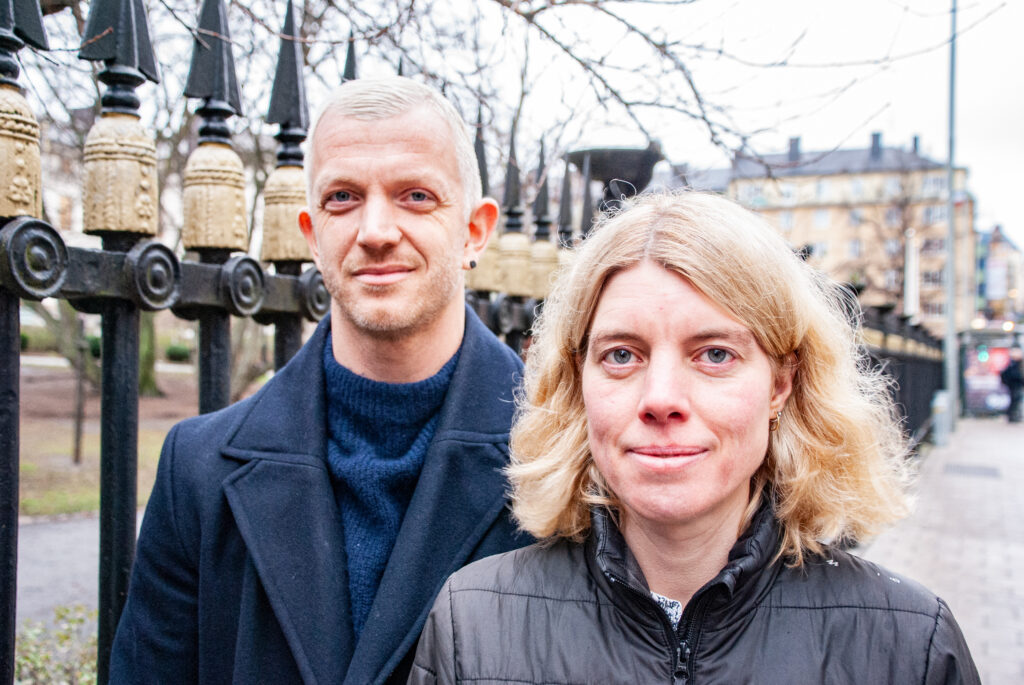 Anna Sehlin och Jonas Lindberg framför Landstingshusets staket